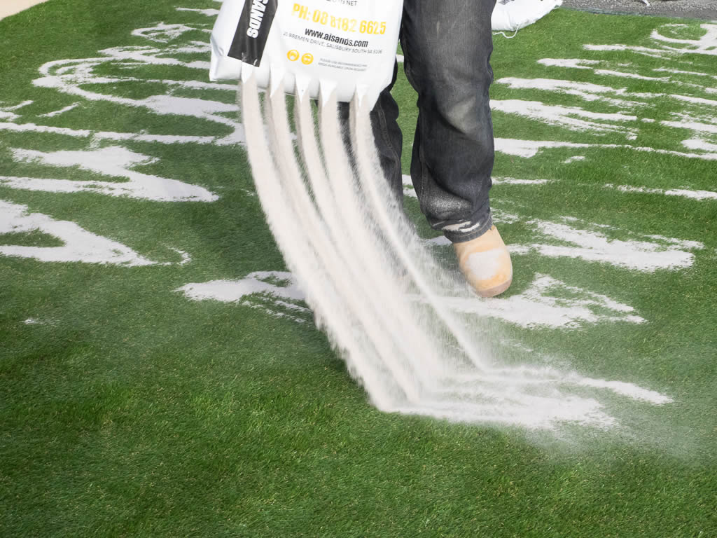 spread kiln dried sand over artificial grass